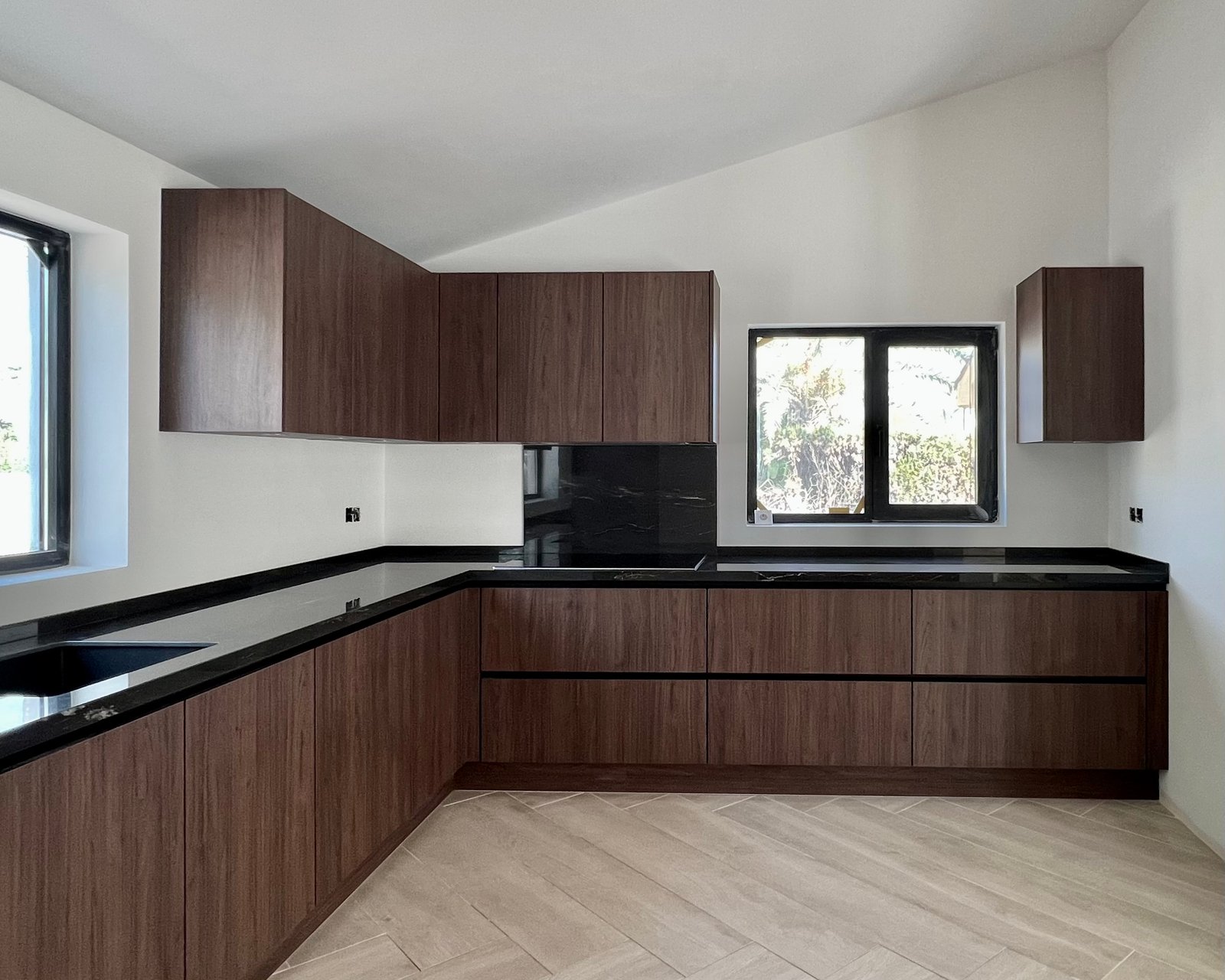 Walnut kitchen with a black worktop, fitted by Next Level
